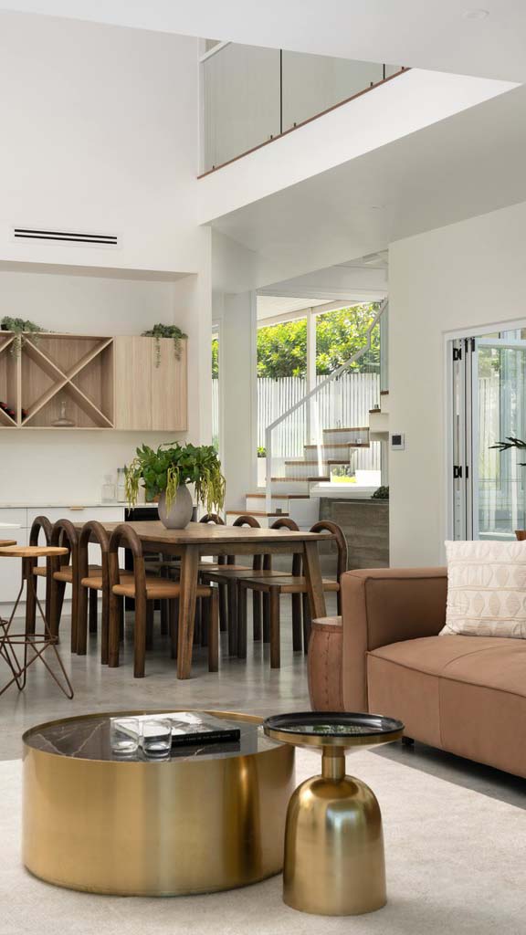 A double-height area in a bright modern home with open-plan dining and living.
