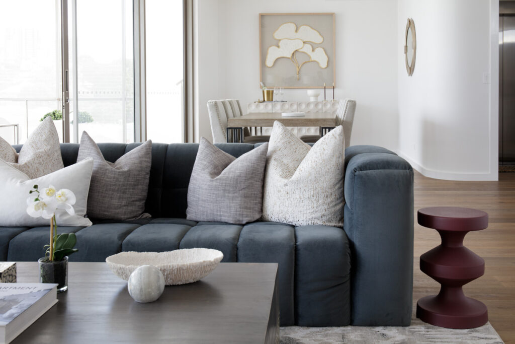 Cosy blue sofa, unique side tables and a dining area behind it