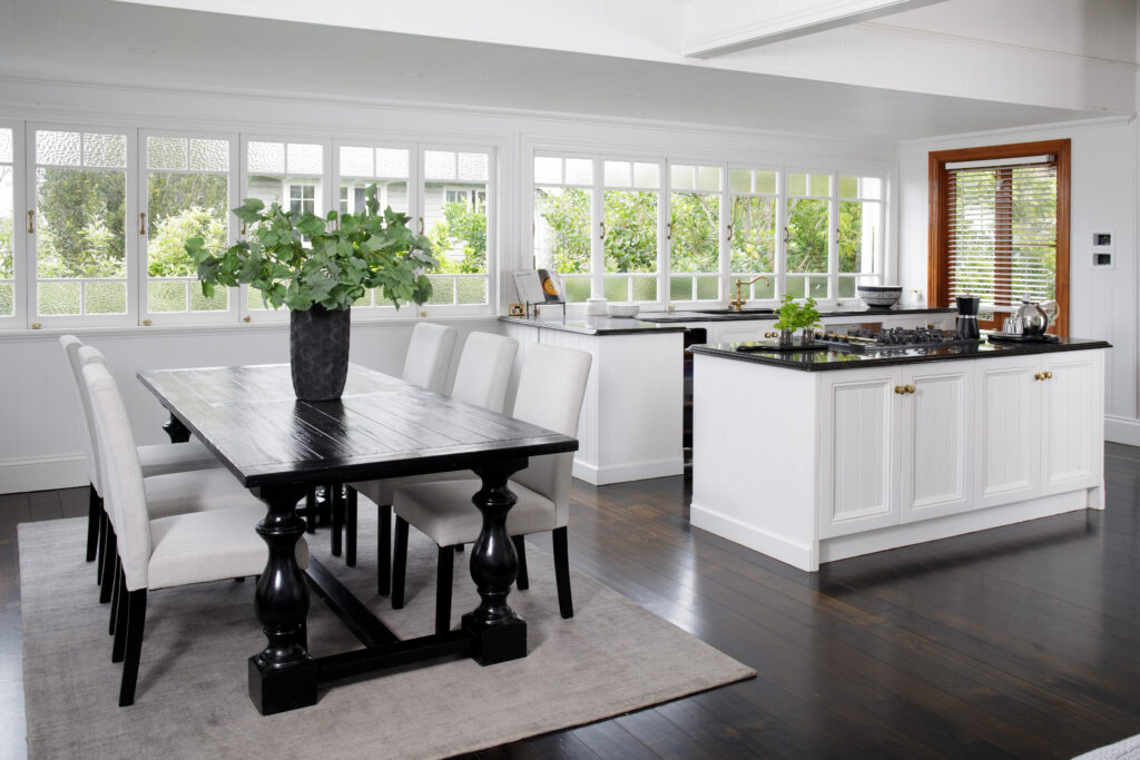 Open plan kitchen dining area with a dark wood floor and white units