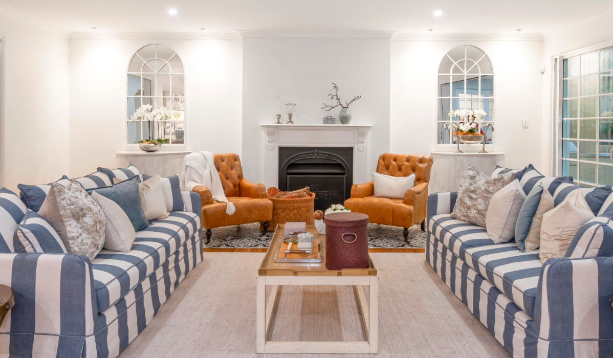 Cosy living room with blue and white striped sofas and orange chairs