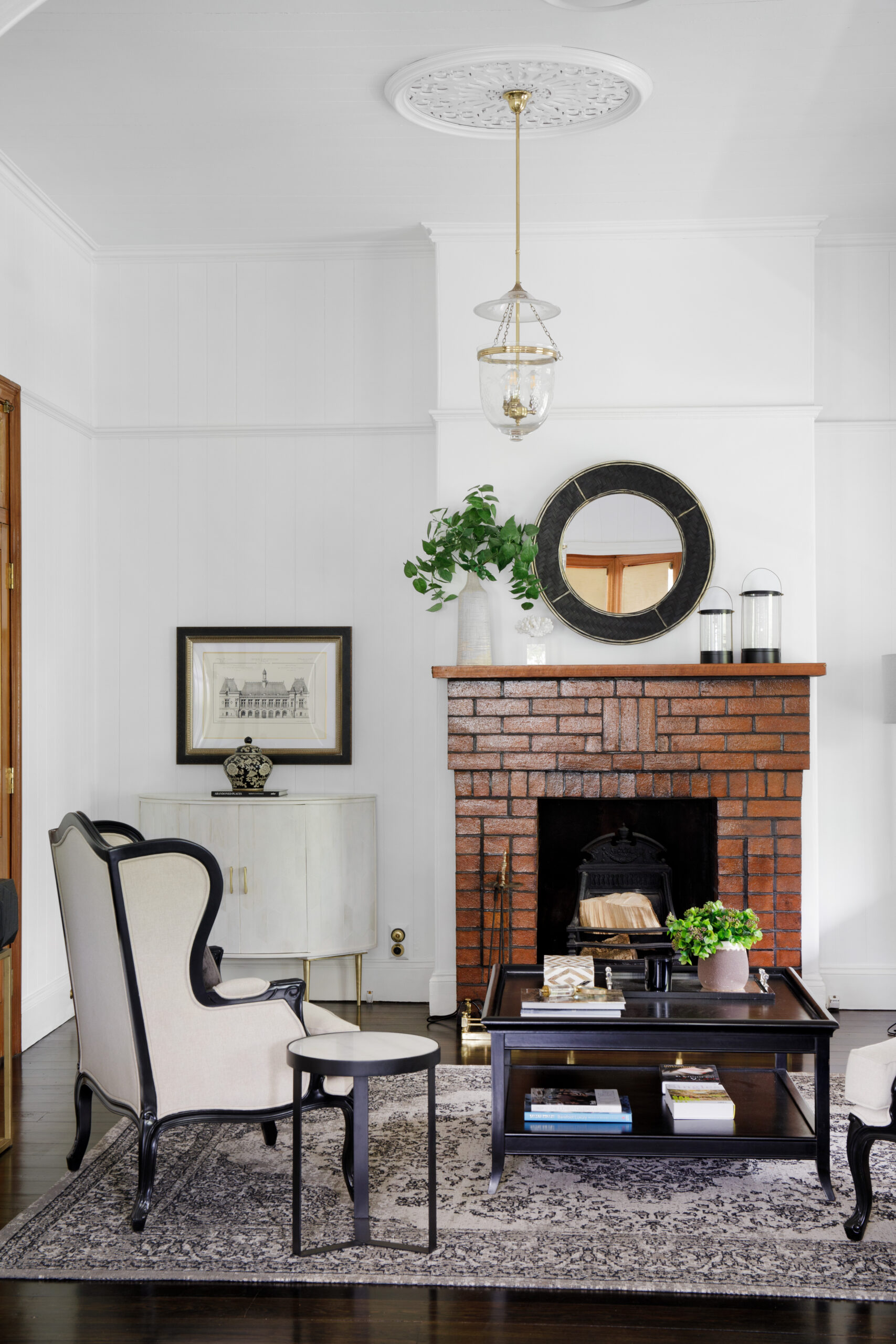 Seating area in a white room with a brick fireplace.
