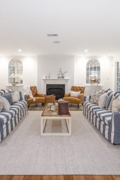 Cosy living room with blue and white striped sofas open to outdoors