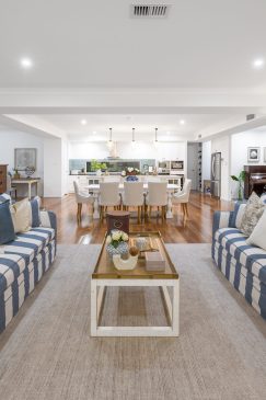 Two long blue and white striped sofas facing each other in an open plan living, dining and kitchen room