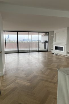 Empty living room with a wood herringbone floor