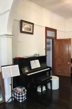 Before renovation photo of a room with a piano