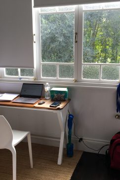 Before photo of a bedroom with a desk and laptop