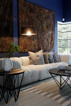 Blue living room with cosy neutral sofa and feature side lamp