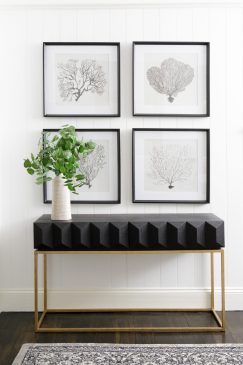 A side unit, plant in a vase and wall art