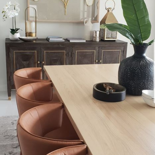 A dining table, chairs and a side table, styled with accessories.